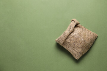 One burlap sack on olive background, top view. Space for text