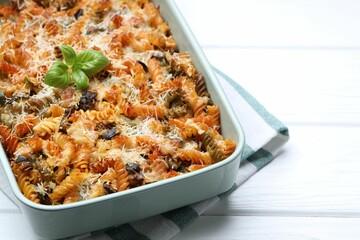 Delicious al forno pasta in baking dish on white wooden table, closeup