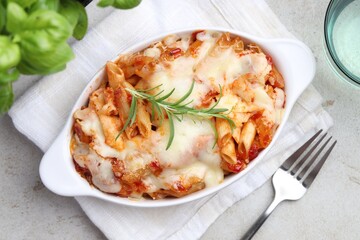 Delicious al forno pasta in baking dish on light table, top view