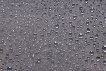Water drops on gray background, top view