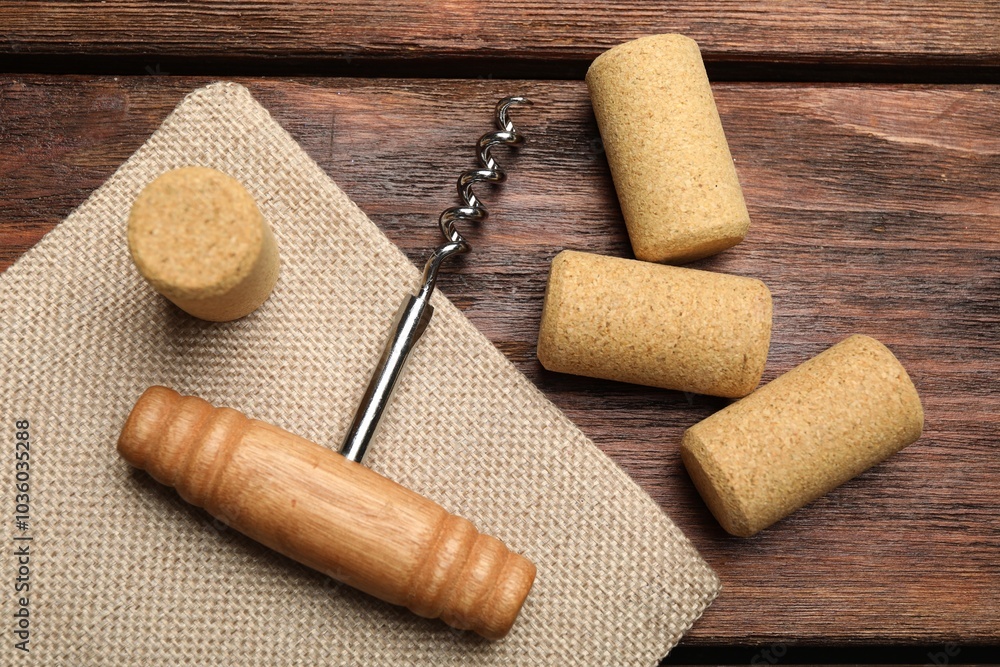 Poster Corkscrew and corks on wooden table, flat lay