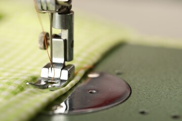 One sewing machine with thread on blurred background, macro view. Space for text