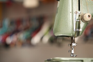 Vintage sewing machine with thread on blurred background, macro view. Space for text