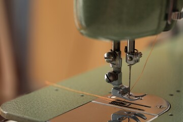 Vintage sewing machine with thread on blurred background, macro view