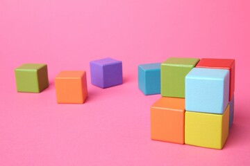 Obraz premium Many wooden colorful cubes on pink background
