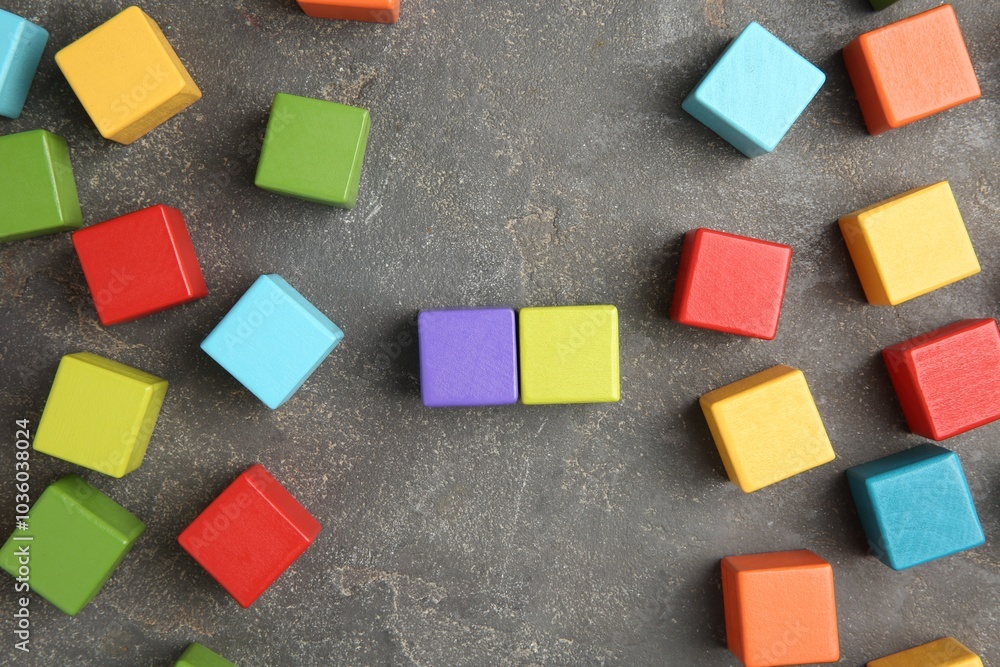 Poster Many wooden colorful cubes on gray textured background, top view