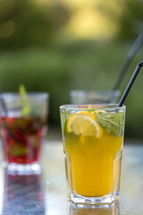 A glass of orange juice with a slice of lime in it sits on a table