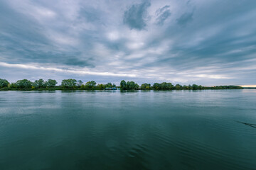 A calm lake with a cloudy sky in the background