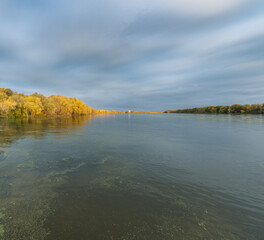 A calm lake with a cloudy sky in the background