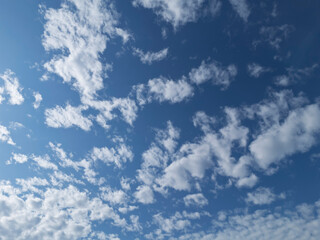 Obraz premium Vibrant blue sky with fluffy white clouds, creating a serene and peaceful atmosphere. Perfect for backgrounds or nature-related projects.