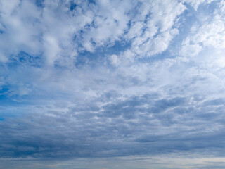A beautiful expansive view of the sky filled with fluffy clouds in various shades of blue and gray, perfect for background use or nature-themed projects.