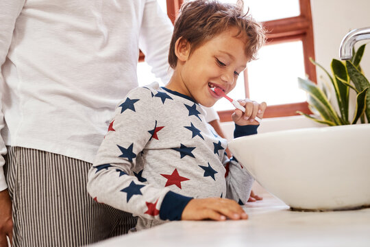 Dad, son and brushing teeth in bathroom, home and teaching with help, happy and wellness. Hygiene, father and boy with parent, family or cleaning mouth with guidance, remove plaque or dental with joy
