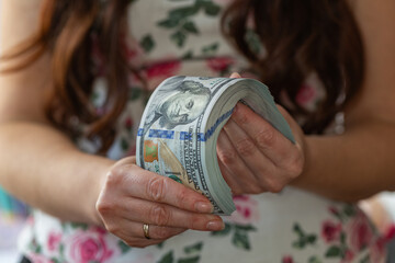 Woman hands holding pile of 100 US dollar banknotes