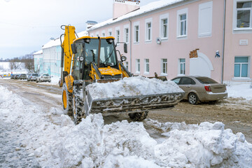 A snow plow is clearing the snow from the road