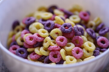 A white bowl filled with vibrant colorful cereal.