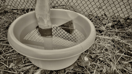 The farmer placed the axe in water poured into a green basin so that the handle would not fly off...