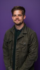 Obraz premium Smiling Young Man in Green Jacket Against Deep Purple Background for Professional Portrait