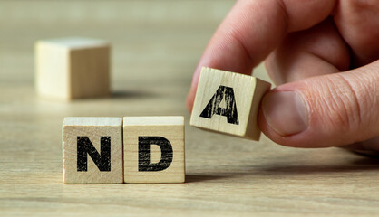 A close-up of a person's hand arranging wooden blocks with the letters NDA to symbolize confidentiality and agreements