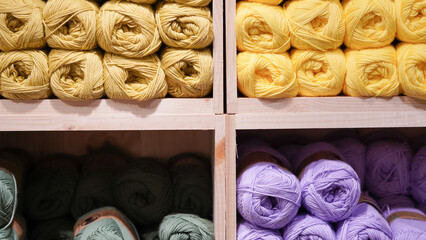 Colorful yarn threads displayed on a shop window, inviting creativity and warmth