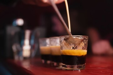 Shot preparation. Night club, bar. Close-up bartender's hand pou