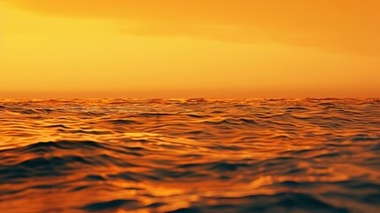 Obraz premium A hazy and grainy gradient of warm oranges and yellows sink into a serene and textured ocean capturing the essence of a tranquil sunset.
