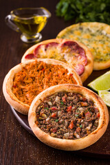 Variety of Delicious Pide with Savory Toppings on Wooden Board