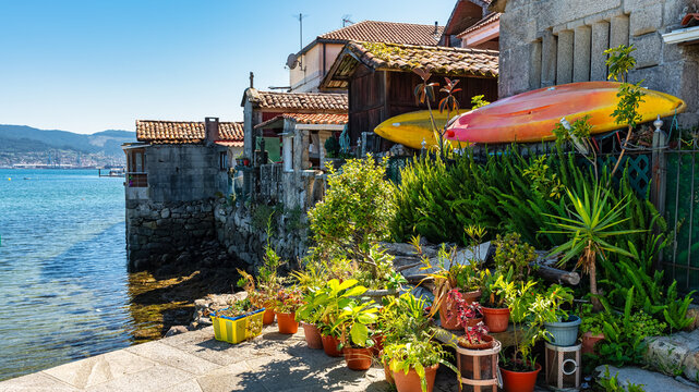 Old stone houses and granaries with plants and flower decoration on the coast of Pontevedra, Combarro