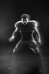 American Football Player in Action: A dynamic, motion-blurred image of an American football player in a powerful stance, ready for the next play.