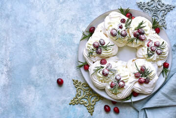 Christmas meringue cake Pavlova with cranberry and rosemary . Top view with copy space.