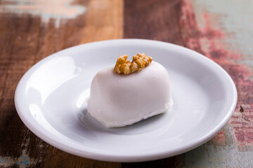 Elegant White Dessert Topped with Walnut on Rustic Table