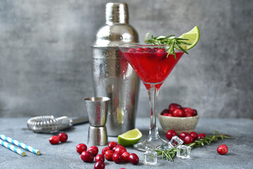 Cranberries cocktail with fresh lime in a martinil glass .