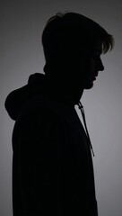 Man silhouetted with hood on dark backdrop anonymous figure in hoodie