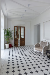 Elegant hallway with patterned flooring and double doors in a well-lit, minimalist interior space