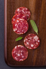 Sliced Salami on Wooden Board with Fresh Herbs Garnish