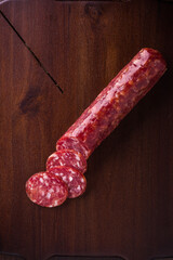 Sliced Salami on Wooden Cutting Board with Dark Background