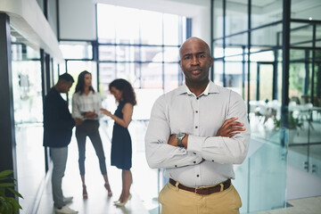Fototapeta premium Crossed arms, office and portrait of business black man for confidence at work, career and job with team. Serious, corporate manager and person for professional mindset, company growth and success