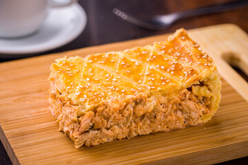 Delicious Homemade Empadao (Chicken Pie) Slice on Wooden Cutting Board