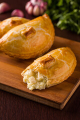 Delicious Golden Empadas With Creamy Palmito Filling on Wooden Board