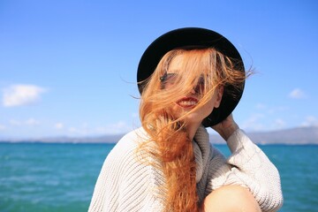 Autumn portrait of happy smiling young woman wearing a sweater and hat. 