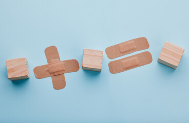 Plaster, medical and healthcare in studio, wooden blocks and protection for wood care and surgical dressing. Blue background, treatment and prevention of infection, health and bandage in hospital