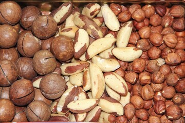 A close up shot of an iron box filled with assorted nuts, white background.