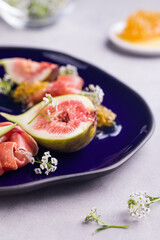 Gourmet Dish with Fresh Figs and Delicate Garnish on Blue Plate