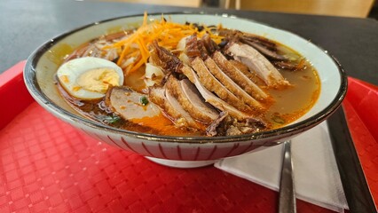 Delicious bowl of ramen with pork, egg, and vegetables