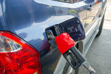 Gun refueling gasoline or diesel in a blue car.Energy crisis, oil crisis. Full tank. Gasoline...