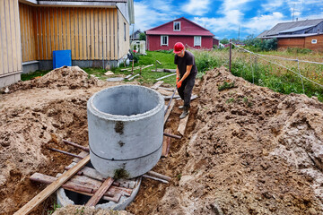 Moving concrete ring along roller deck during installation of an autonomous sewerage system in rural area.