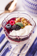 Elegant Dessert With Yogurt, Fresh Berries, And Nuts In Glass Cup