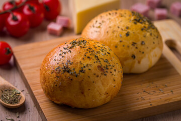 Freshly Baked Herb-Crusted Bread Rolls on Wooden Board