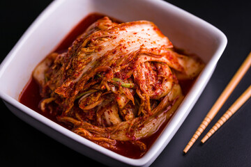 Spicy Korean Kimchi in White Bowl With Chopsticks