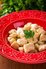 Delicious Homemade Gnocchi Served in a Vibrant Red Bowl