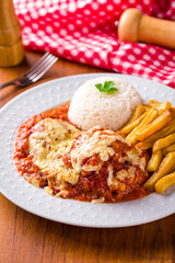 Delicious Chicken Parmesan with Rice and Golden Fries on Plate